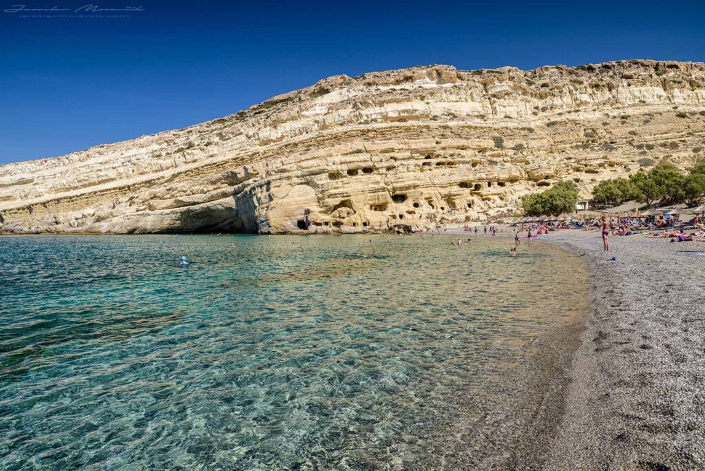 Matala Beach na Kréte s jaskyňami v skalách a kamienkovou plážou