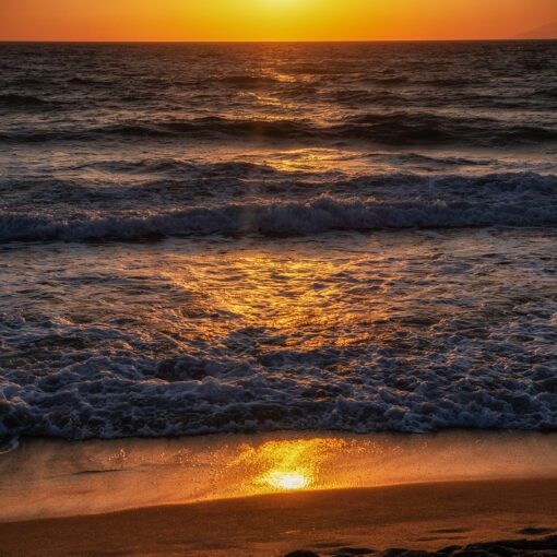 Zlatý západ slnka nad morom na pláži Kalamaki, Kréta