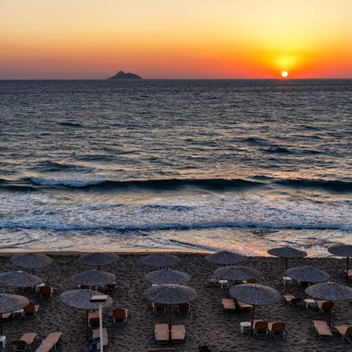 Večerný pohľad na pláž Kalamaki počas západu slnka, Kréta