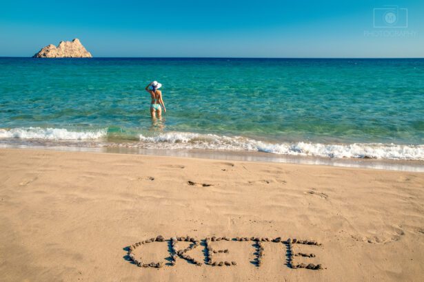 Mazida Ammos Beach na Kréte pri Xerokampos s pieskovou plážou, priezračným morom a nápisom Crete v piesku