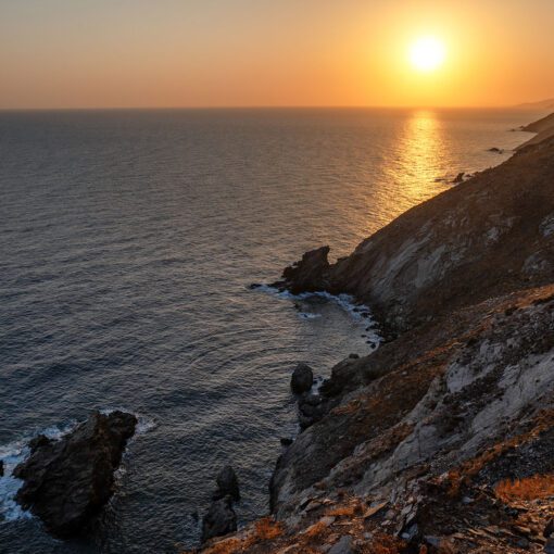 Západ slnka nad útesmi Kréty – pokojné more pri Panormose