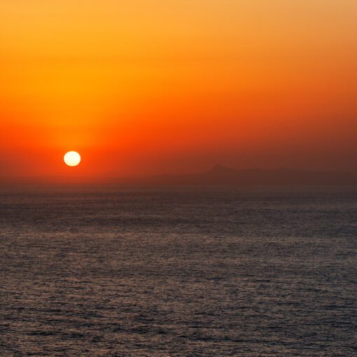 Zlatý západ slnka a hory Kréty v diaľke – Panormos