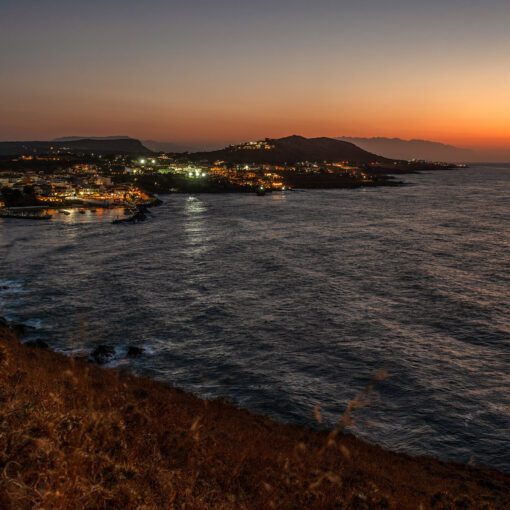 Nočný pohľad na osvetlené pobrežie Panormosu – Kréta