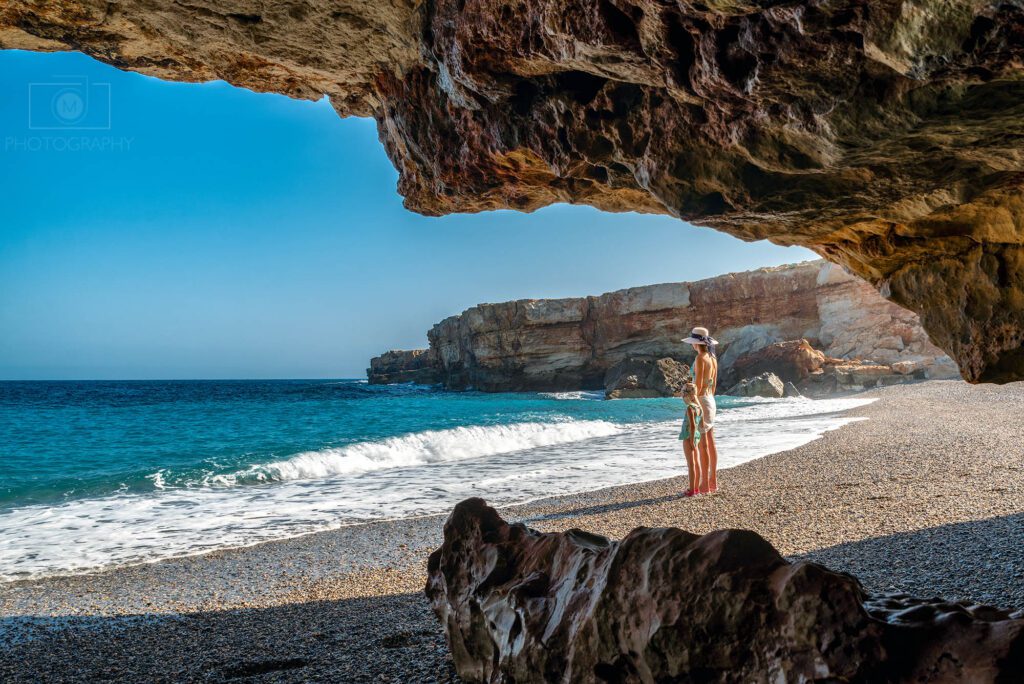 Spilies Beach na severnom pobreží Kréty s kamienkovou plážou, skalnou jaskyňou a tyrkysovým morom